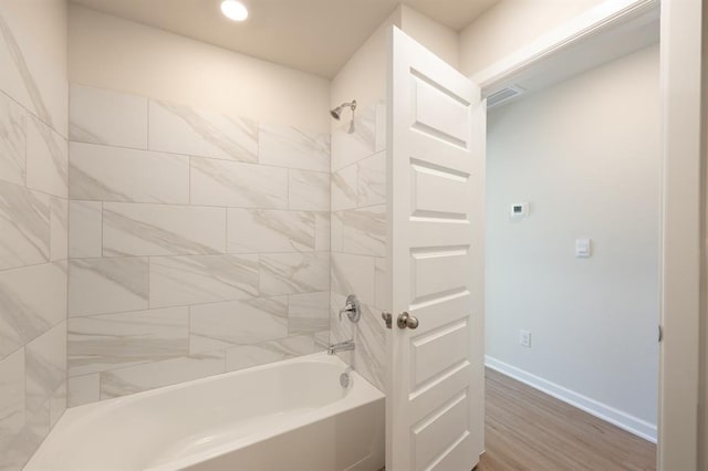 full bathroom with baseboards, wood finished floors, tub / shower combination, and recessed lighting