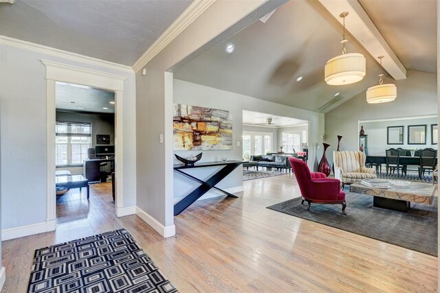 interior space with vaulted ceiling with beams, ornamental molding, baseboards, and wood finished floors