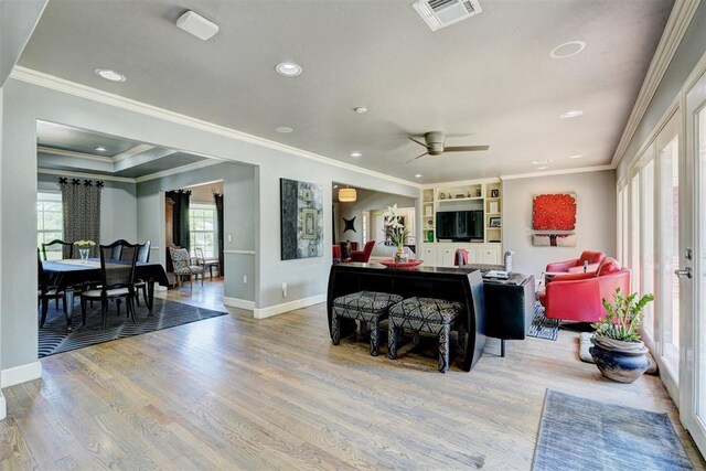 living room featuring baseboards, a ceiling fan, wood finished floors, and visible vents