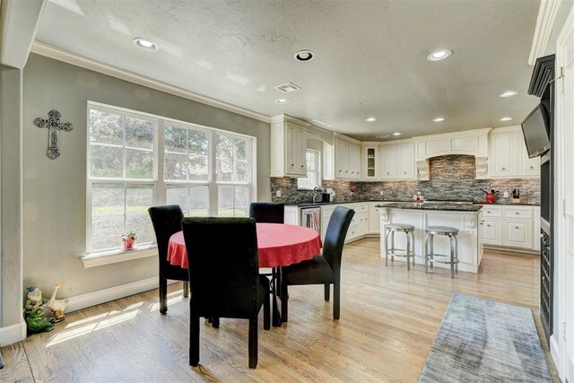 dining space with visible vents, crown molding, baseboards, light wood-style floors, and recessed lighting