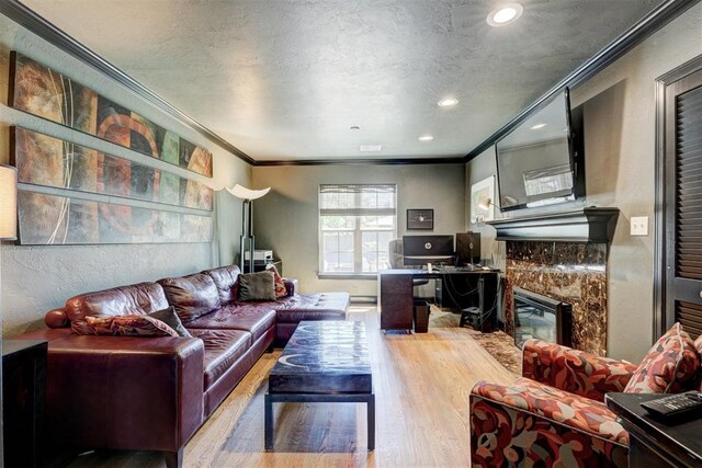 living room featuring crown molding, recessed lighting, a textured ceiling, and wood finished floors