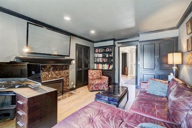 living room with light wood-style floors, ornamental molding, and recessed lighting