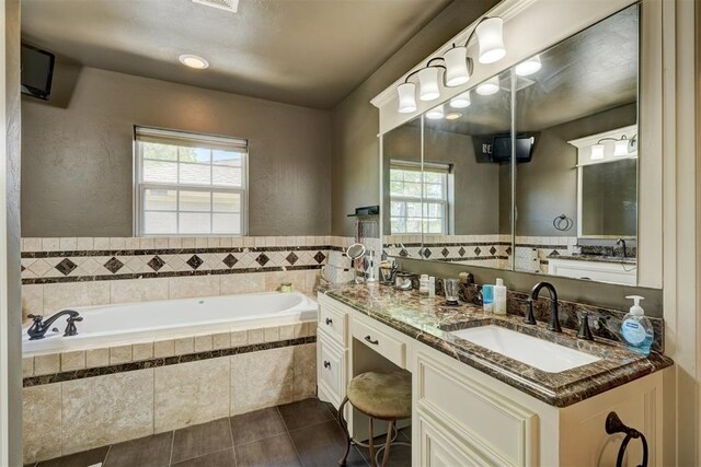 bathroom featuring vanity, tile patterned flooring, and a garden tub