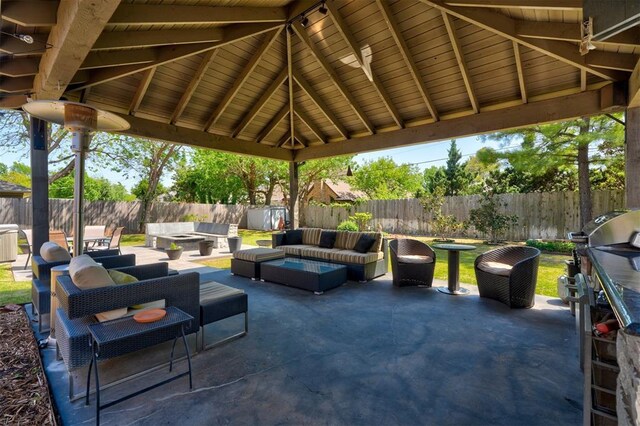 view of patio / terrace with grilling area, a gazebo, a fenced backyard, and an outdoor living space with a fire pit