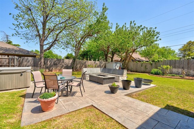 view of patio with a fenced backyard, a hot tub, and a fire pit