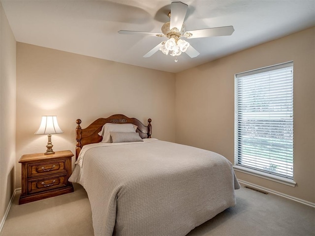 carpeted bedroom featuring baseboards, visible vents, and multiple windows