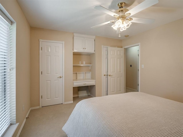bedroom with baseboards, ceiling fan, and light colored carpet