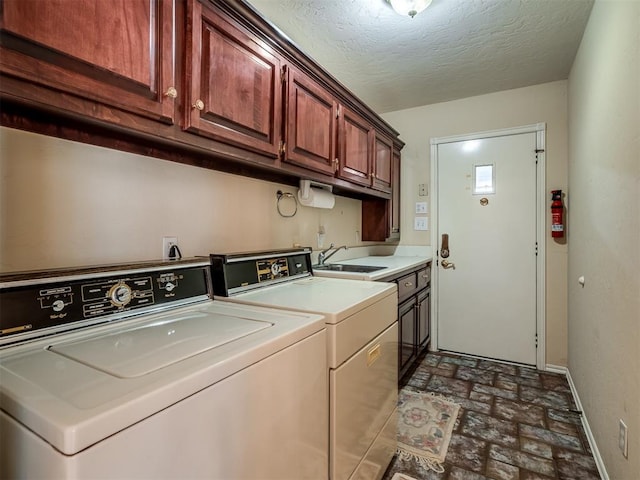 clothes washing area with independent washer and dryer, a sink, baseboards, cabinet space, and brick floor