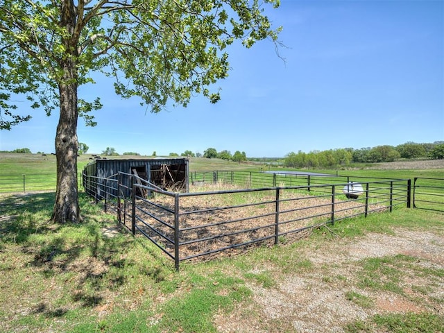 view of yard featuring a rural view, an outdoor structure, and an exterior structure