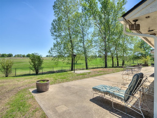 view of patio / terrace with fence and a rural view