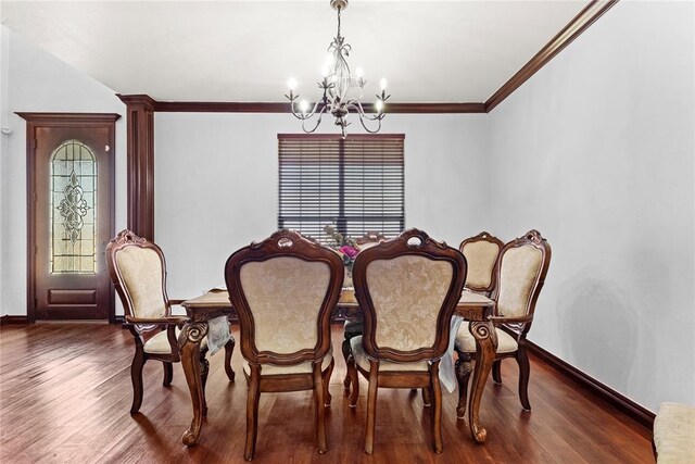 dining area with wood finished floors, crown molding, baseboards, and an inviting chandelier