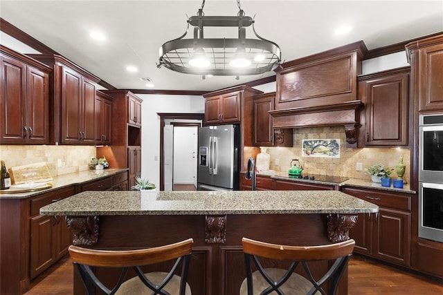 kitchen featuring stainless steel appliances, decorative backsplash, light stone counters, crown molding, and a breakfast bar area