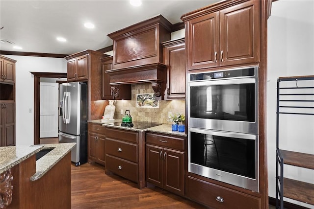 kitchen featuring recessed lighting, light stone counters, backsplash, appliances with stainless steel finishes, and dark wood-style flooring