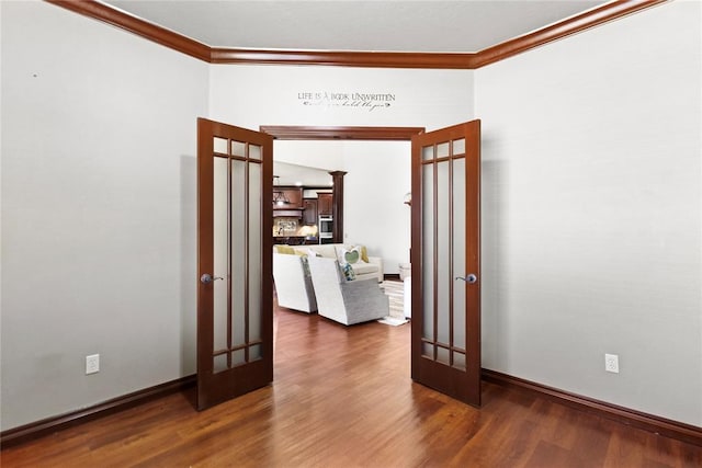 unfurnished room featuring wood finished floors, baseboards, ornamental molding, and french doors