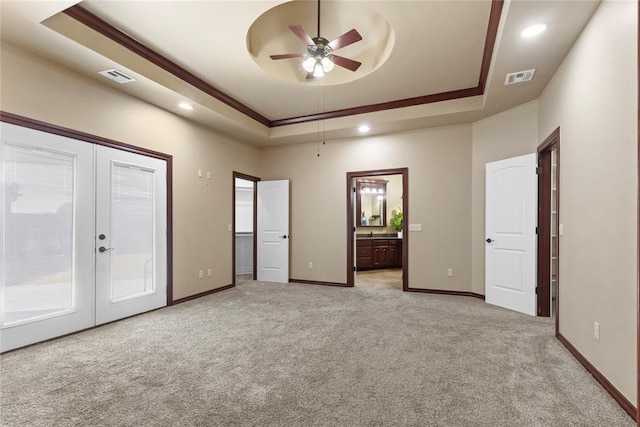 interior space featuring a tray ceiling, visible vents, access to outside, and light carpet