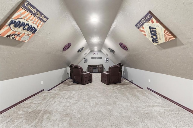 cinema with vaulted ceiling, a textured ceiling, baseboards, and carpet