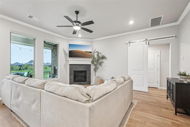 3320 Lola Ct, Moore, OK 73160 - living area featuring ceiling fan, light wood-type flooring, a barn door, and visible vents