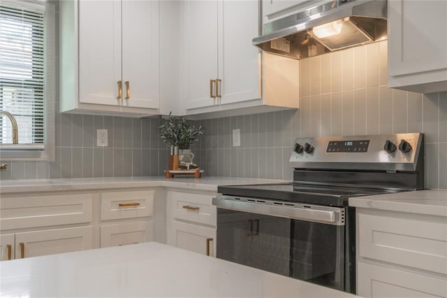 3224 NW 47th St, Oklahoma City, OK 73112 - kitchen featuring electric stove, under cabinet range hood, light countertops, backsplash, and a sink