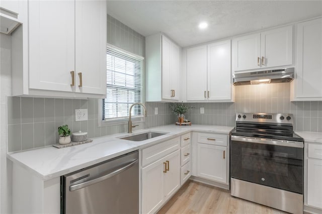 3224 NW 47th St, Oklahoma City, OK 73112 - kitchen featuring a sink, under cabinet range hood, decorative backsplash, white cabinets, and appliances with stainless steel finishes