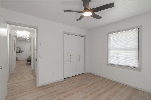 3224 NW 47th St, Oklahoma City, OK 73112 - unfurnished bedroom with a closet, ceiling fan with notable chandelier, light wood-style flooring, and baseboards