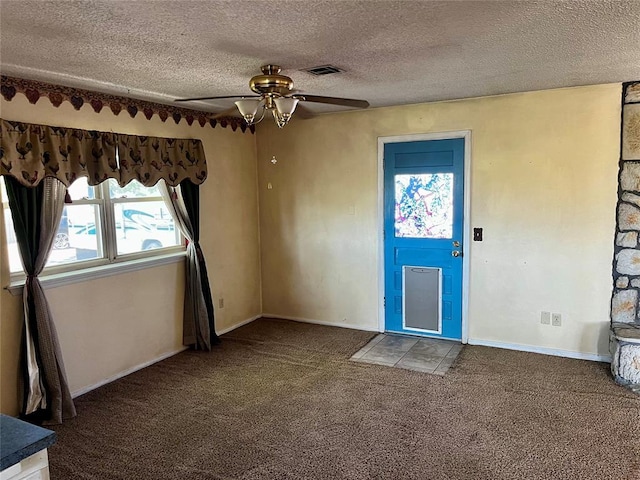 interior space with carpet floors, a ceiling fan, a textured ceiling, and visible vents