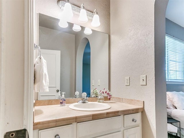 3401 Kentucky Way, Edmond, OK 73034 - bathroom with connected bathroom, a textured wall, and vanity