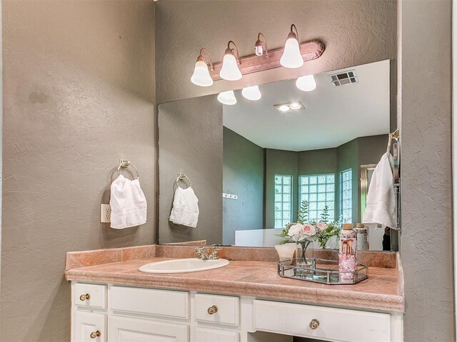 3401 Kentucky Way, Edmond, OK 73034 - bathroom with a textured wall, visible vents, and vanity