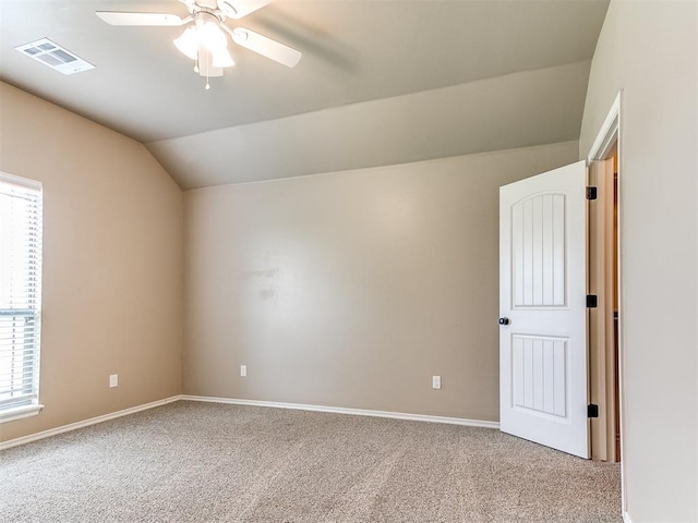 interior space featuring visible vents, carpet floors, lofted ceiling, baseboards, and a ceiling fan