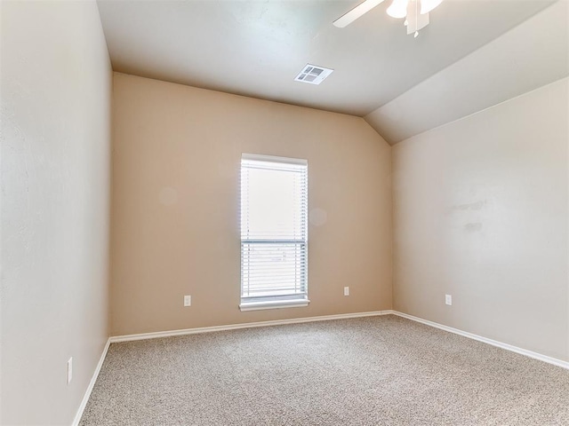 empty room featuring ceiling fan, visible vents, baseboards, lofted ceiling, and carpet flooring