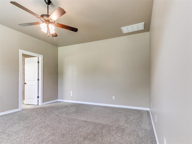 carpeted spare room featuring baseboards, a ceiling fan, and visible vents