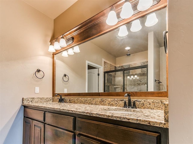 bathroom with double vanity, a sink, and a stall shower