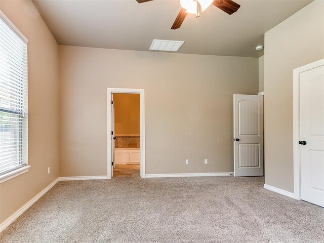 unfurnished bedroom featuring a ceiling fan, visible vents, carpet floors, baseboards, and connected bathroom