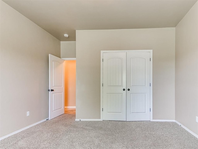 unfurnished bedroom with baseboards, carpet, and a closet