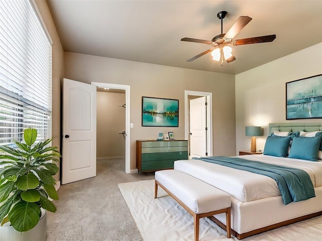 bedroom with light colored carpet, a ceiling fan, and baseboards