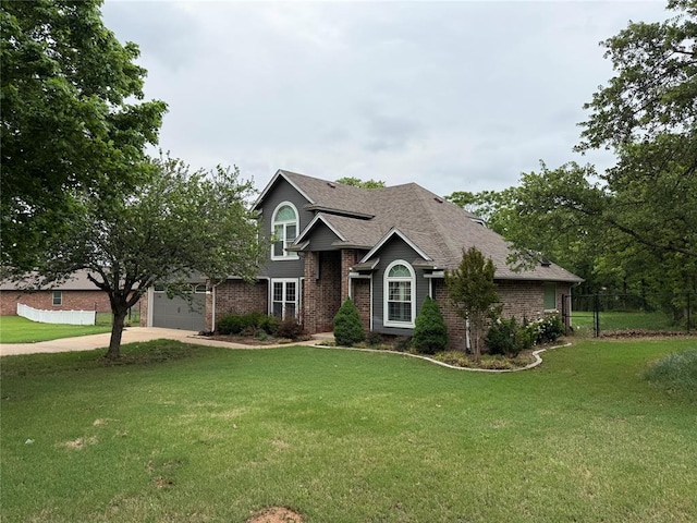 traditional-style home with fence, a front yard, driveway, and brick siding