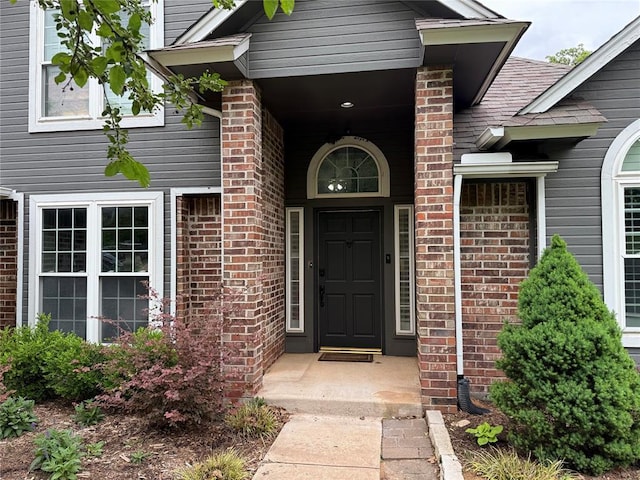 view of exterior entry featuring brick siding