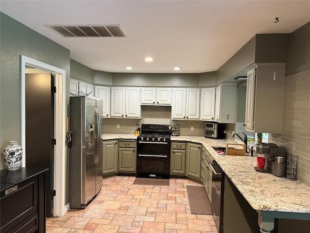 kitchen with visible vents, dishwashing machine, stainless steel fridge, a sink, and double oven range