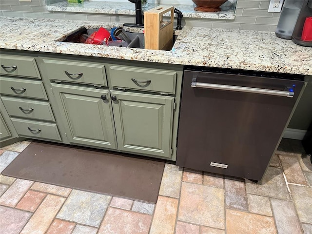 interior details featuring green cabinetry, decorative backsplash, a sink, and dishwasher
