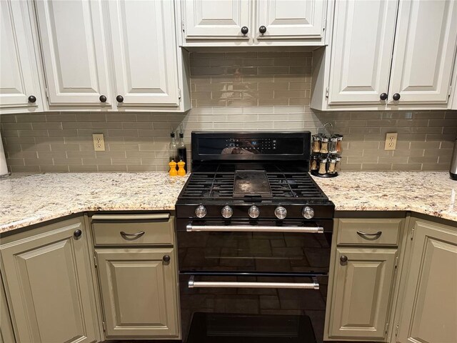 kitchen featuring backsplash, white cabinets, and gas stove