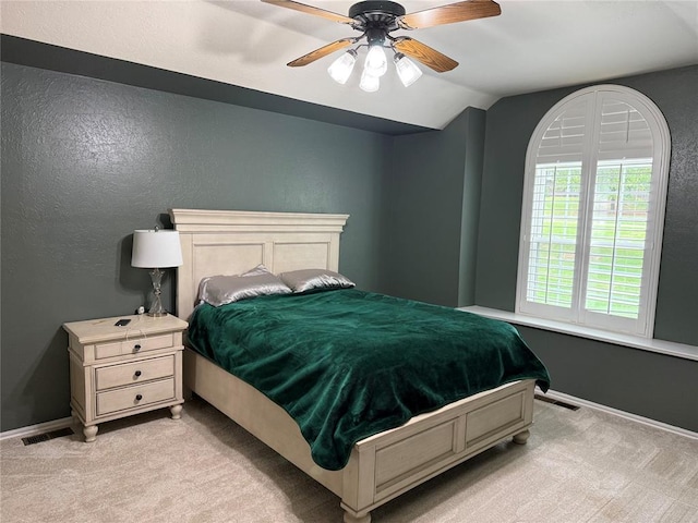bedroom featuring light colored carpet, baseboards, lofted ceiling, and visible vents