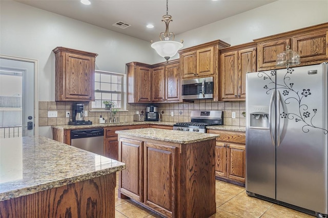 kitchen featuring backsplash, visible vents, a sink, a center island, and appliances with stainless steel finishes