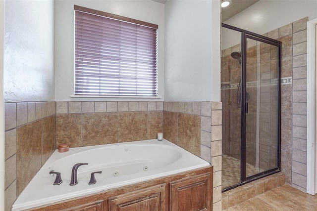 bathroom with a jetted tub and a stall shower