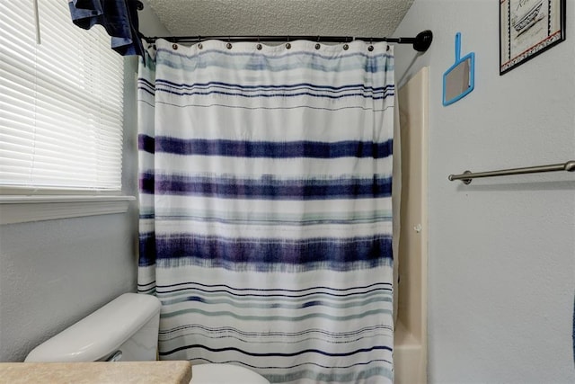 full bath with vanity, a textured ceiling, and toilet