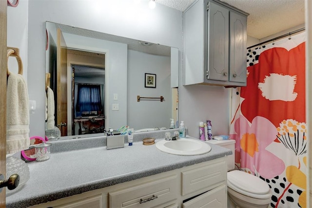 bathroom with vanity, a textured ceiling, toilet, and a shower with curtain