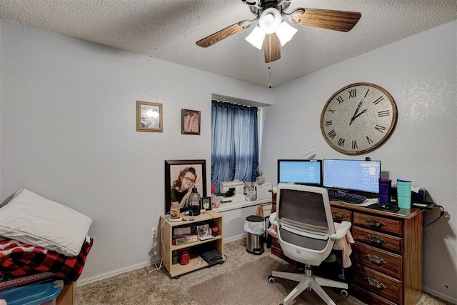 carpeted office space featuring baseboards, a textured ceiling, and ceiling fan