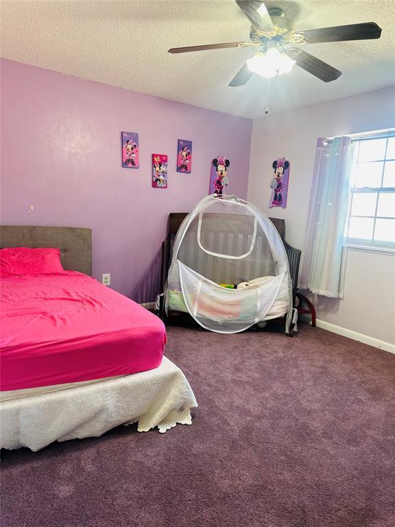 bedroom with baseboards, a ceiling fan, carpet flooring, and a textured ceiling
