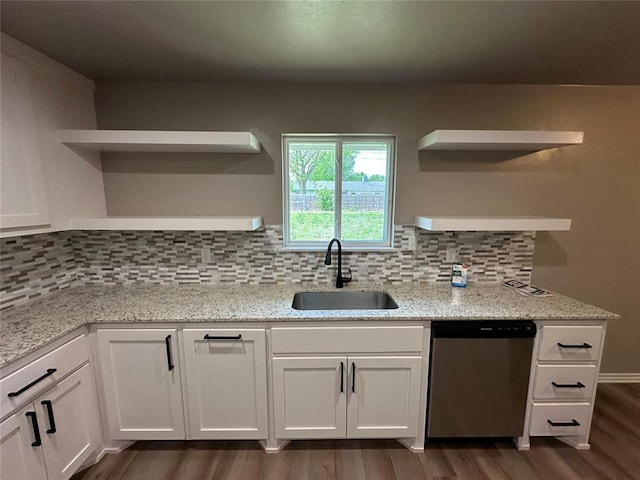 kitchen with a sink, open shelves, white cabinets, stainless steel dishwasher, and dark wood-style floors