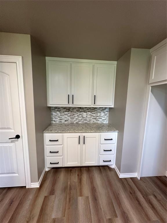 interior space with baseboards, dark wood-style flooring, and tasteful backsplash