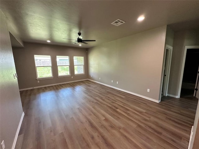 spare room featuring baseboards, ceiling fan, visible vents, and wood finished floors