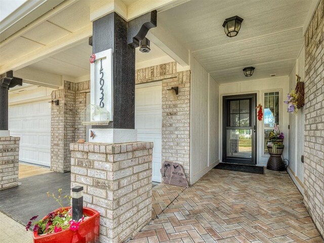 15936 Buffalo Dr, Oklahoma City, OK 73170 - view of exterior entry with a garage, brick siding, and covered porch